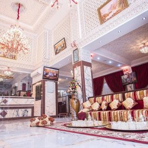 Интерьер гостиницы с декоративной мебелью и элементами роскоши, включая диваны и люстры.
