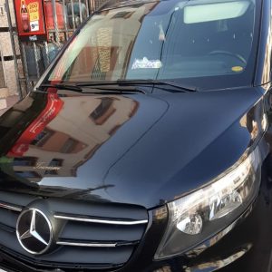 Черный микроавтобус Mercedes-Benz с номерным знаком и логотипом на передней решетке.